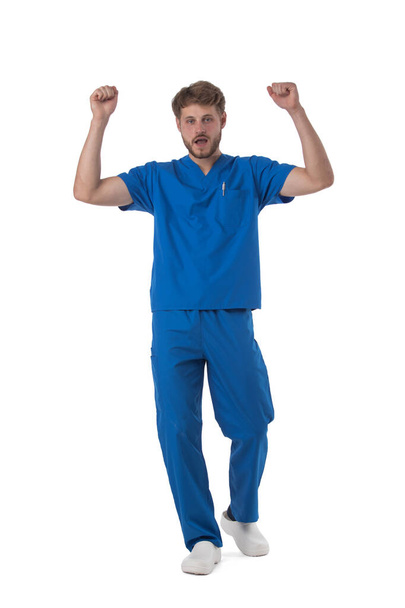 Молодий чоловік медичної медсестри працівник охорони здоров'я з піднятими руками ізольовані на білому тлі повнометражний студійний портрет
 - Фото, зображення