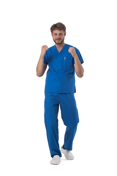 Young male medical nurse healthcare worker holding fists isolated on white background full length studio portrait - Фото, зображення