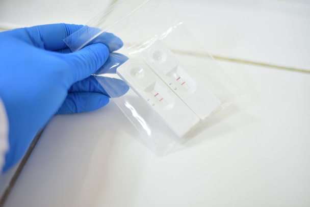 Käsi lääketieteellinen teknologi testaus covid-19 antigeeni positiivinen odottaa vahvistaa reaaliaikainen PCR. - Valokuva, kuva