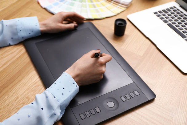 Professional designer with graphic tablet at wooden table, closeup - Photo, Image