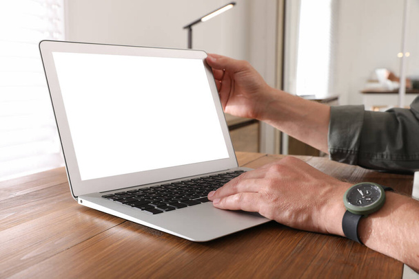 Modern dizüstü bilgisayarı olan bir adam ahşap masada, yakın plan. Tasarım için boşluk - Fotoğraf, Görsel