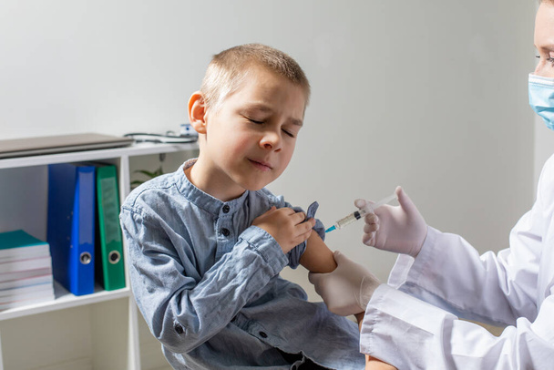 Portrait of lovely brave preschooler boy while routine vaccination - Foto, Imagen