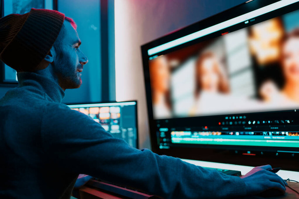 Αρσενικός επεξεργαστής βίντεο που εργάζεται στον προσωπικό υπολογιστή του με μεγάλη οθόνη - Φωτογραφία, εικόνα