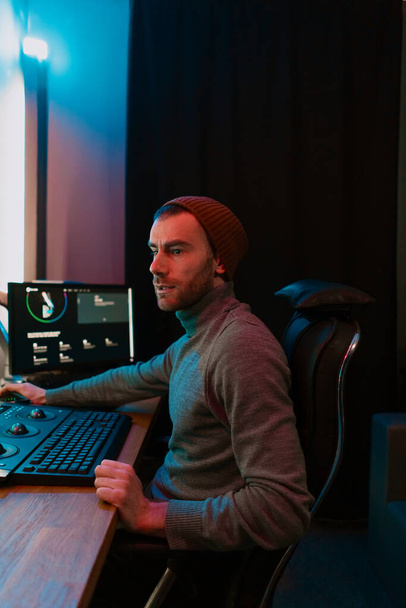 Editor de vídeo masculino trabajando en su ordenador personal con pantalla grande - Foto, Imagen