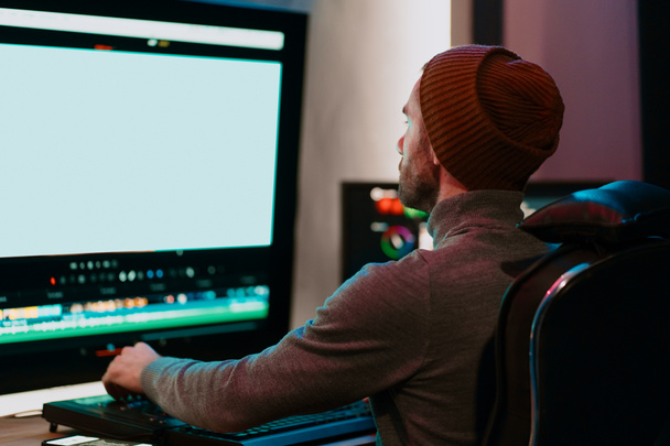 Editor video maschile che lavora sul suo personal computer con grande display vuoto - Foto, immagini