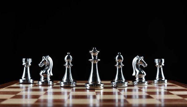Silvery chess figures standing on chessboard - Foto, Imagen