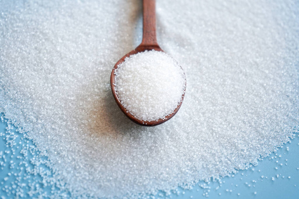 close up of sugar cubes on wooden spoon - Foto, afbeelding