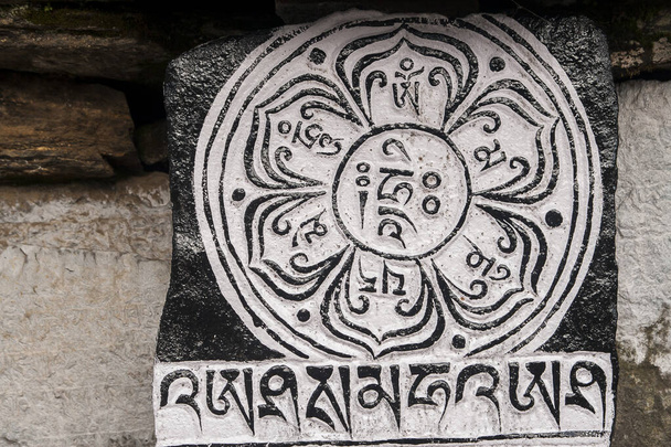 CHAURIKHARKA, NEPAL - CIRCA OKTOBER 2013: Mani stenen met de inscriptie mantra is een van de elementen van de boeddhistische religie rond oktober 2013 in Chaurikharka. - Foto, afbeelding