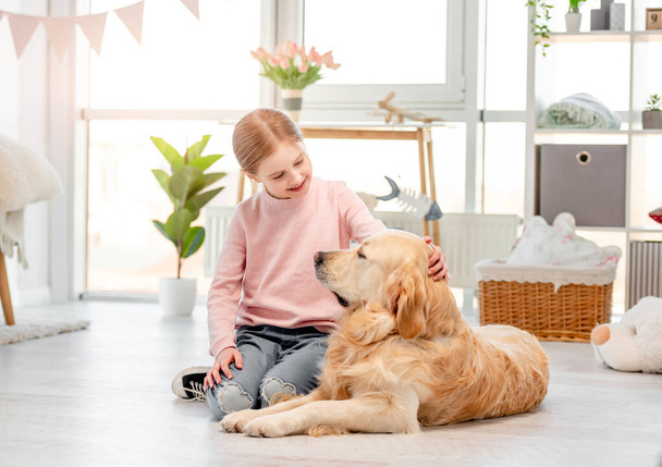 Little girl with golden retriever dog - Foto, immagini