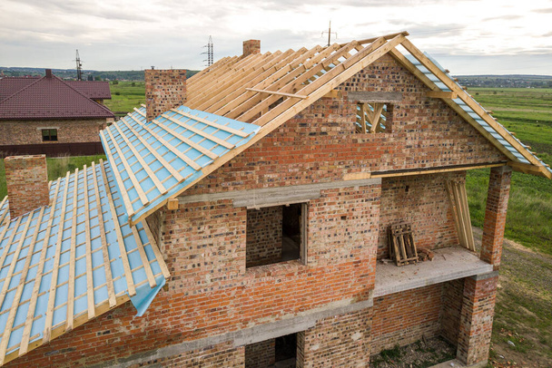 Ahşap çatı iskeleti olan tuğladan bir evin havadan görünüşü. - Fotoğraf, Görsel
