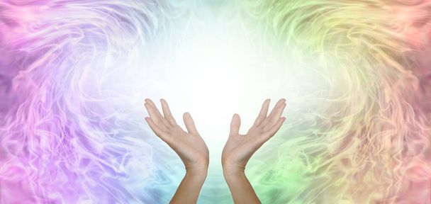 Praca ze skalarną informacją o uzdrawiającej energii baner - kobiece dłonie z białym światłem między na tle bladego tęczowego wzoru tła z przestrzenią do kopiowania wiadomości  - Zdjęcie, obraz