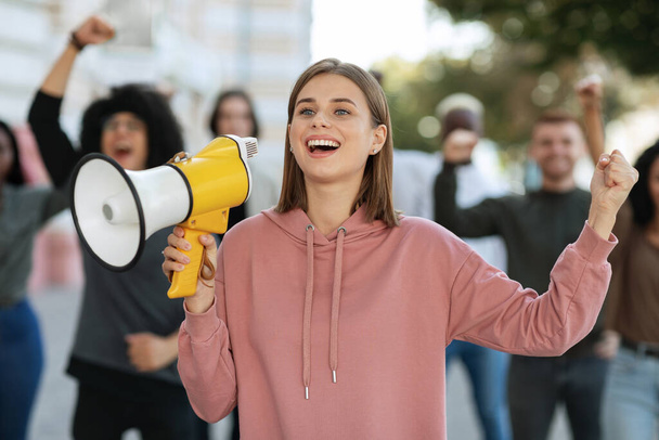 Ενθουσιασμένη ξανθιά ακτιβίστρια με μεγάφωνο στο δρόμο - Φωτογραφία, εικόνα