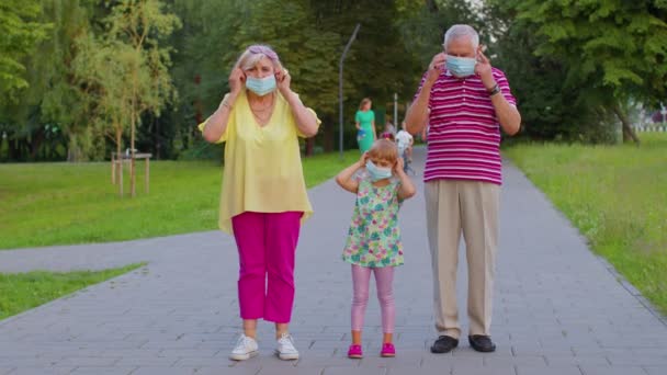 シニアカップル祖母祖父とともに孫娘身に着けています医療保護マスクコロナウイルス - 映像、動画