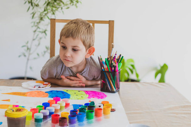 The little boy paints at the table - 写真・画像