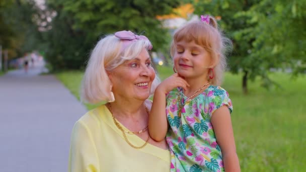 Klein kleindochter kind omarmen zoenen met haar grootmoeder in park, gelukkig familie relatie - Video