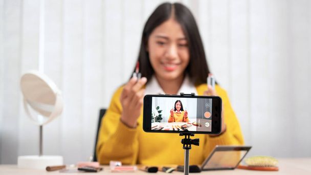 アジアの女性は自宅でインターネットによるソーシャルネットワークに美容化粧品製品や放送ライブビデオを提示し、美容ブロガーの概念 - 写真・画像