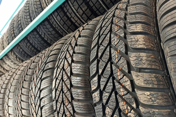 Muchos neumáticos de goma negro del coche en estante de la tienda para la venta. - Foto, Imagen