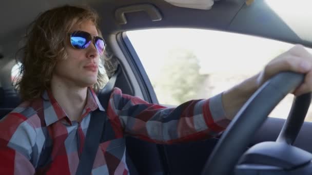 Man met een blauwe zonnebril in een auto.. - Video