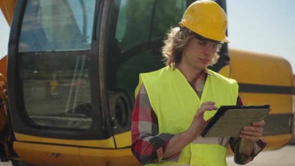 Operatore escavatore in cappello rigido utilizzando tablet pc. - Filmati, video