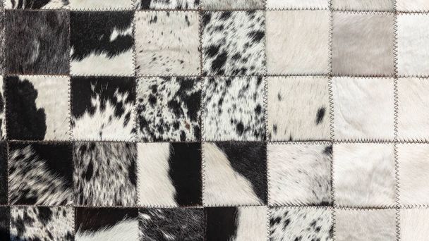 Bovino piel de animal piel de cuero alfombra cueros primer plano foto imagen abstracto fondo detalle de limpiar tratado cosido juntos bloques cuadrados para hacer alfombra alfombra decoración estilo de vida interior. - Foto, imagen