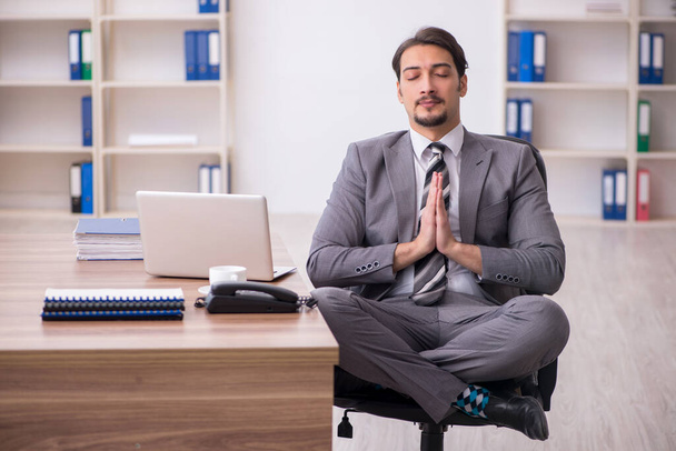 Young attractive male employee sitting at workplace - Φωτογραφία, εικόνα