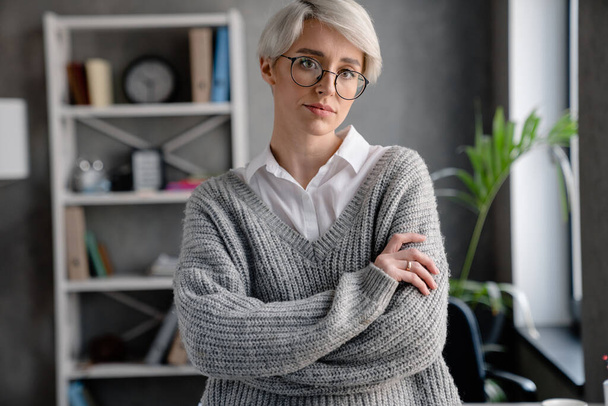 White-haired focused woman looking at camera while standing in office - Foto, Imagem