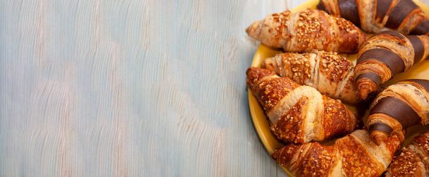 Food banner. Croissants on a plate top view. Place for your text. Fresh pastries on a plate. Bakery. Chocolate croissant and walnut croissant for breakfast. - Fotografie, Obrázek
