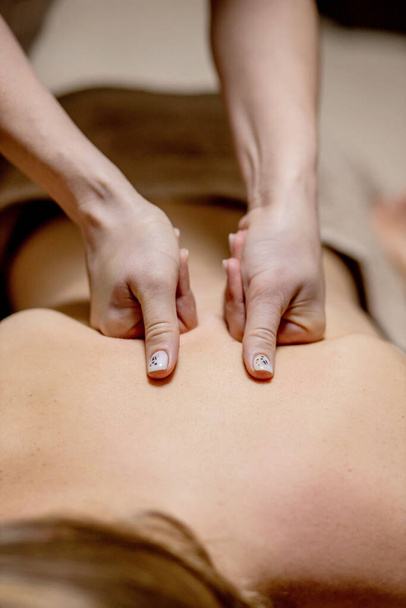 Masseur doing massage on man body in the spa salon. Beauty treatment concept - Photo, image