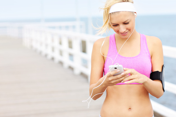 Young fit woman with phone - Photo, Image