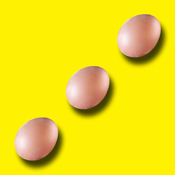Top view, Set of three eggs standing isolated on yellow for background or stock photo, Design, Food, Healthy, Minimal - Photo, Image