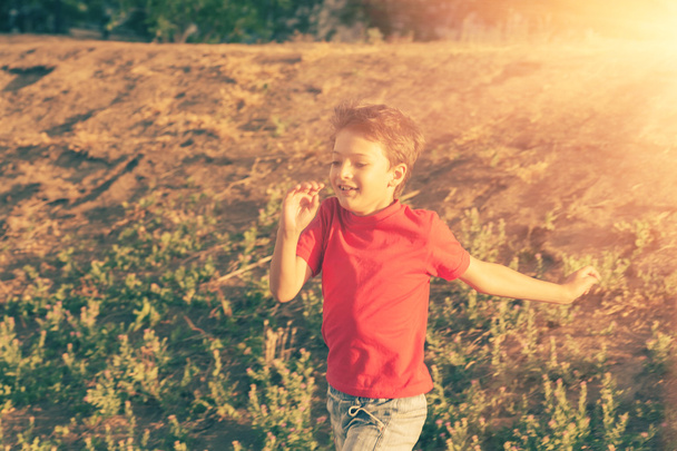 Blurred motion of a boy  running against sun - Zdjęcie, obraz