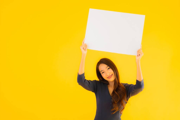 Muotokuva kaunis nuori aasialainen nainen tyhjä ja tyhjä mainostaulu kortin banneri keltainen eristetty tausta
 - Valokuva, kuva