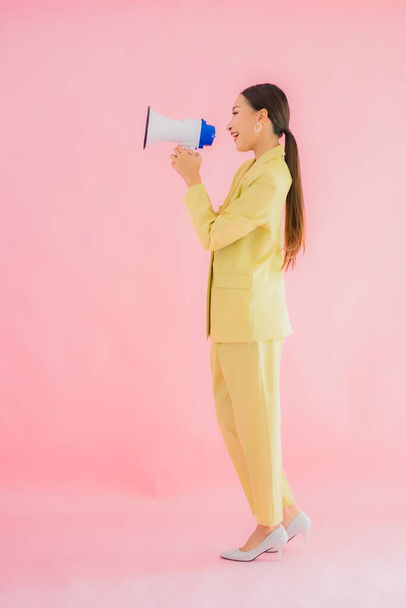 Portrét krásná mladá asijská žena s megafonem na barevném pozadí - Fotografie, Obrázek