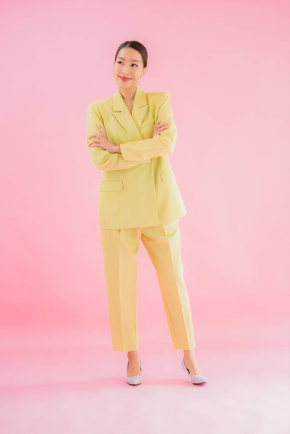 Portrait belle jeune femme d'affaires asiatique sourire en action sur fond de couleur rose - Photo, image
