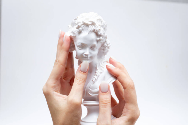 Escultura en miniatura de una mujer y las manos de una mujer con una manicura. - Foto, Imagen