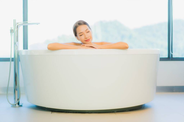 Muotokuva kaunis nuori aasialainen nainen rentoutua vapaa nauttia kylpyammeessa kylpyhuoneessa ja wc sisustus - Valokuva, kuva