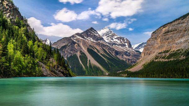 Kinney Lake selymes kinézetű türkiz vize a Robson Tartományi Parkban a kanadai Sziklás-hegységben, Brit Kolumbiában, Kanadában. Fehérszarvú hegy és fahéj csúcs a háttérben - Fotó, kép
