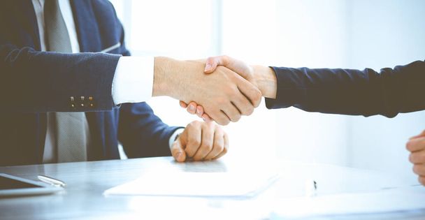 Businesspeople or lawyers shaking hands finishing up a meeting in blue toned office , close-up. Success at negotiation and handshake concepts - Foto, immagini