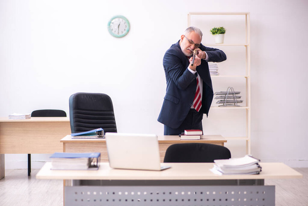 Starý podnikatel zaměstnanec držící riffle v kanceláři - Fotografie, Obrázek