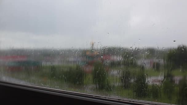 Deszczowy dzień przez okno na tle nieba i budynków miejskich - Materiał filmowy, wideo