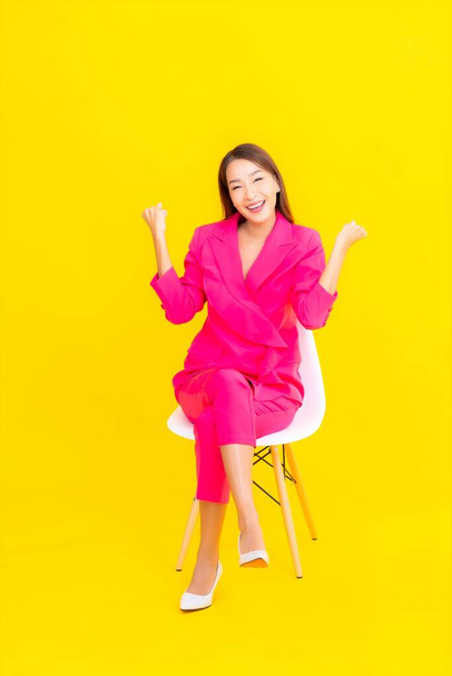 Portrait beautiful young asian woman smile in action on yellow color background - Фото, зображення