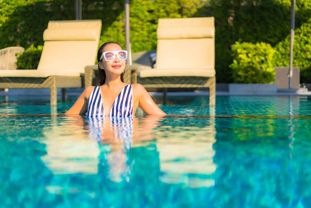 Portrait beautiful young asian woman relax smile leisure on vacation around swimming pool in resort hotel - Photo, Image