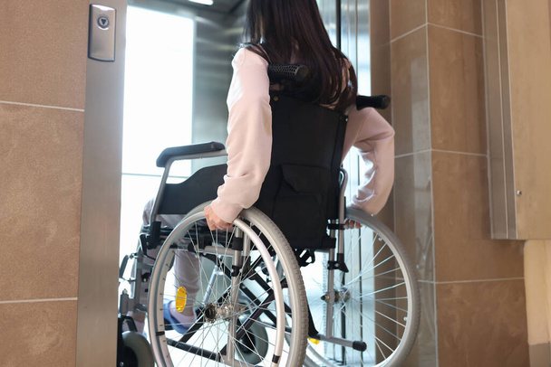 Bezbariérová žena na invalidním vozíku vstupující do výtahu pohled zpět - Fotografie, Obrázek