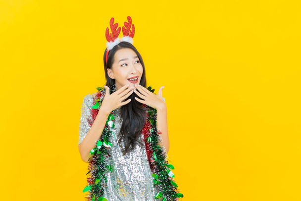Ritratto bella giovane donna asiatica indossare vestito di Natale su sfondo giallo - Foto, immagini