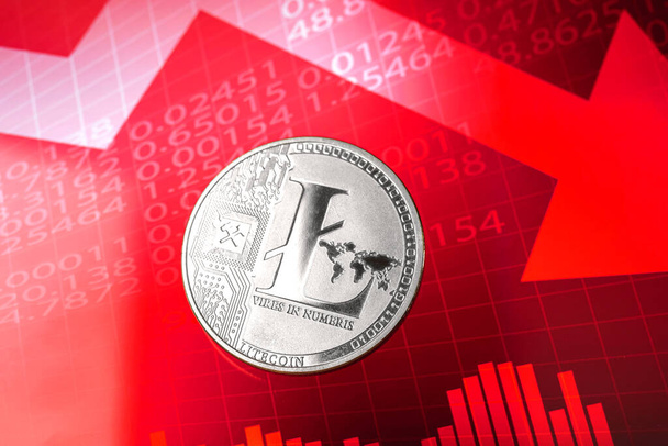 Fall des Litecoin-Kosten- und Wertkurses, Kryptowährungskrisenkonzept, roter Pfeil und Aktiendiagramme auf dem Hintergrund  - Foto, Bild