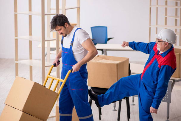Two male professional movers doing home relocation - Фото, зображення