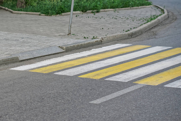 Un exemple de bordure de trottoir munie d'une rampe pour fauteuil roulant et d'une sortie menant à un passage pour piétons. Environnement urbain accessible. Lumière du jour - Photo, image