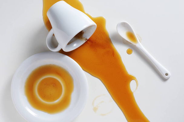 Top kilátás kiömlött csésze kávé fehér asztalon - Fotó, kép