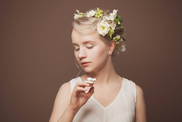 Schönheit Gesicht, Nahaufnahme Porträt der frischen eleganten Dame mit sauberer, gesunder Haut trägt weiße Frühlingsblumen - Foto, Bild