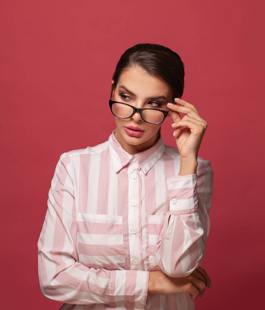 Clever woman in glasses on red background portrait - Φωτογραφία, εικόνα